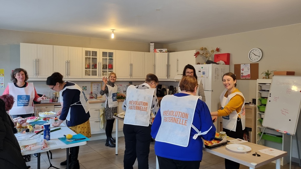 Bénévoles et bénéficiaires du Secours Catholiques s'activent en cuisine