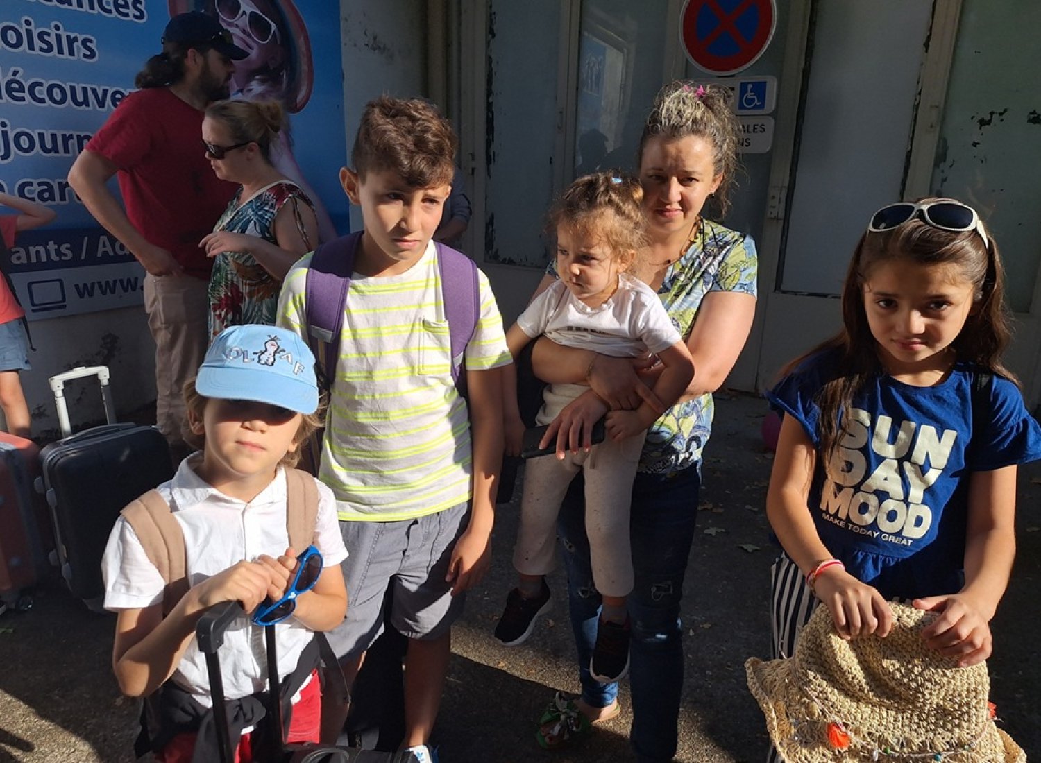 Mme BESSAÏ et ses 3 enfants Salah, Rania et Rayane attendant leur car pour partir en colo