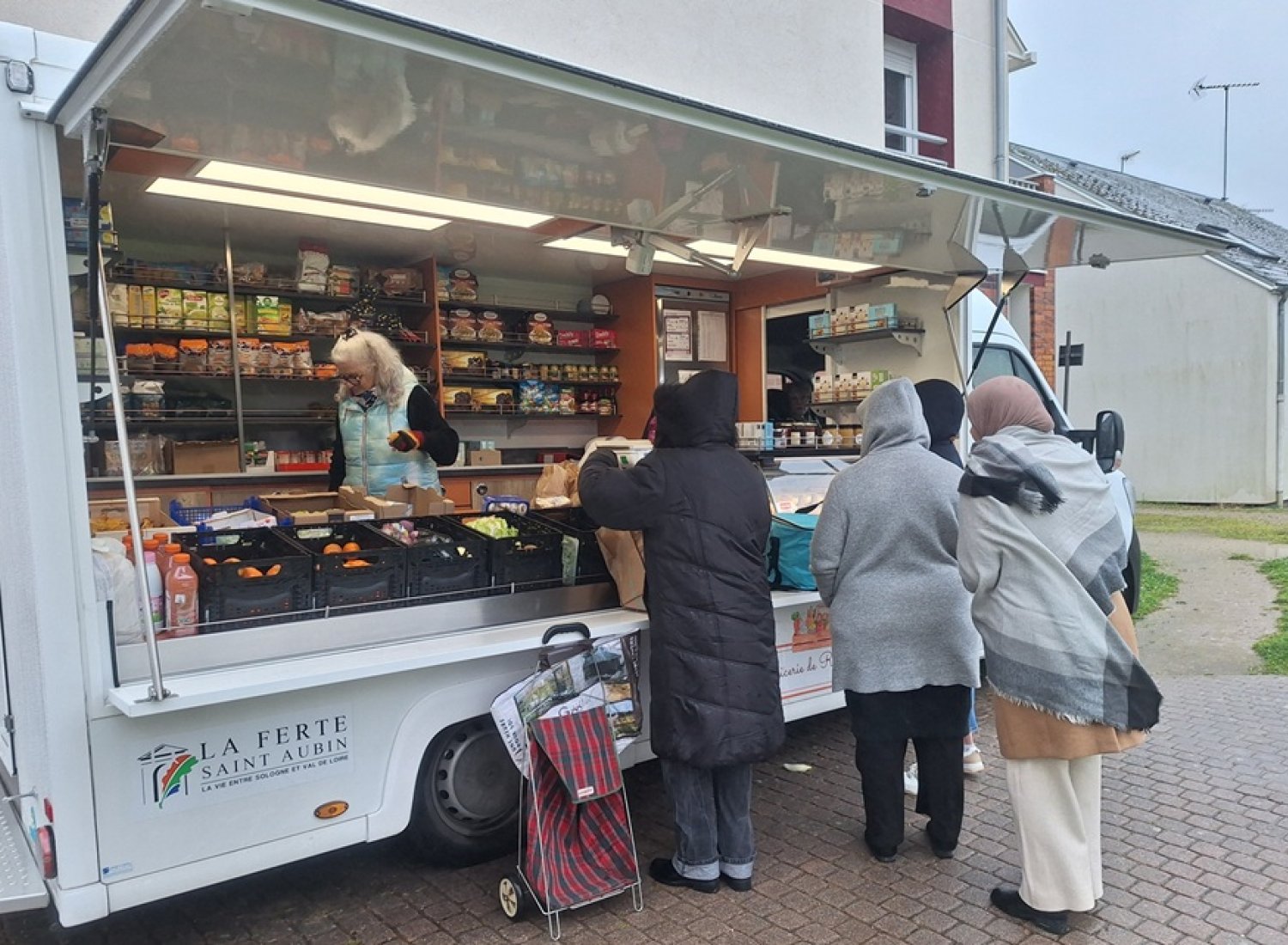 Des bénéficiaires du centre social font leurs courses à l'épicerie solidaire ambulante