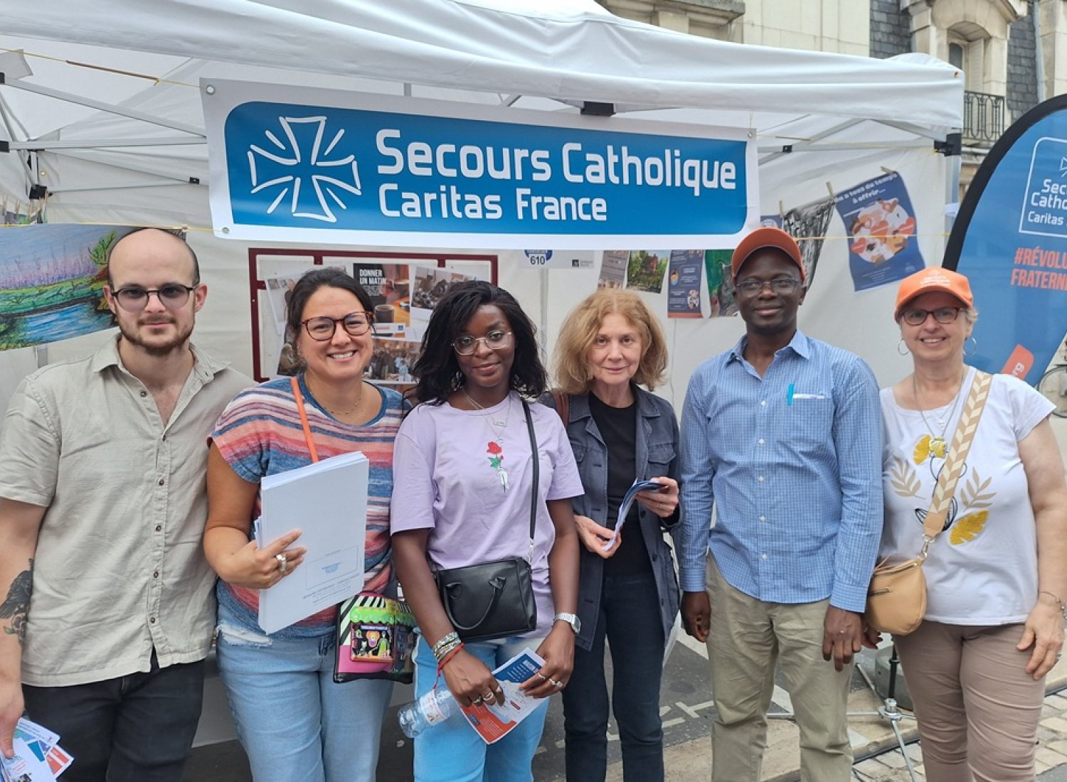 Killian, Pamela, Elsa, Marie-Hélène, Emery et Evelyne, 6 bénévoles devant le stand du Secours Catholique au Forum des associations d'Orléans
